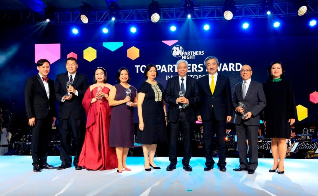 SMPHI President Hans T. Sy (3rd from right), SM Supermalls President Annie Garcia (right) and SVP for Operations Steven Tan (left) present the SM Top Partners Awards for inline stores to Octagon in the IT category received by Jon-Jon San Agustin, Thess Manganti of Let’s Face It in the Wellness category, Xandra Ramos and Precy Ramos of National Bookstore in the Specialty category, Virgilio Lim of Bench in the Fashion category, and William Tan of Jollibee in the Food category during the first SM Partners Awards Night