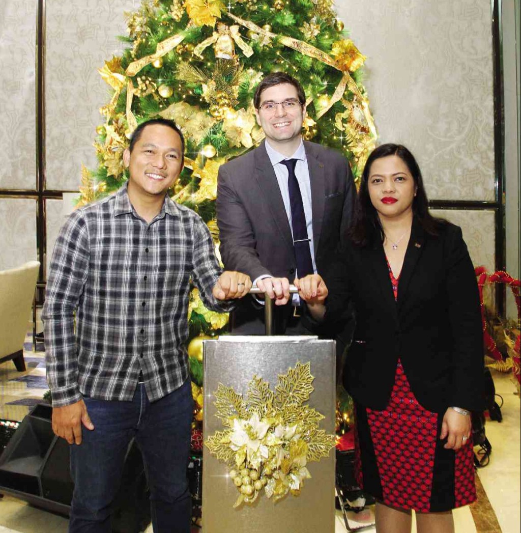 ASCOTT Bonifacio Global City Manila’s residence manager, Philip Barnes (middle) together with Gawad Kalinga’s head of new initiatives Mark Lawrence Cruz and Ascott’s Human Resources director Rosa Manalo pose in front of the Christmas tree during its lighting ceremony held at the hotel lobby. The event was witnessed by corporate clients, guests and the media.
