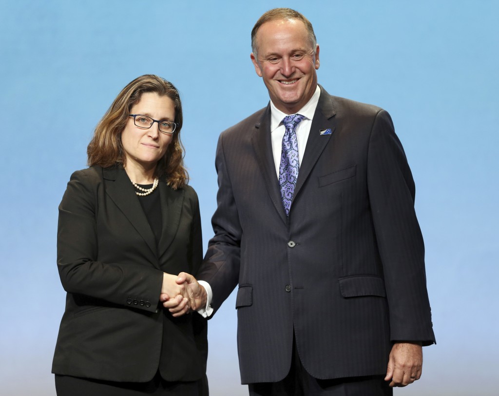 Canada’s Minister of International Trade Chrystia Freeland, left, shakes hands with New Zealand Prime Minister John Key after signing the Trans-Pacific Partnership Agreement in Auckland, New Zealand, Thursday, Feb. 4, 2016. Trade ministers from 12 Pacific Rim countries including the United States have ceremonially signed the free-trade deal. (David Rowland/SNPA via AP) NEW ZEALAND OUT