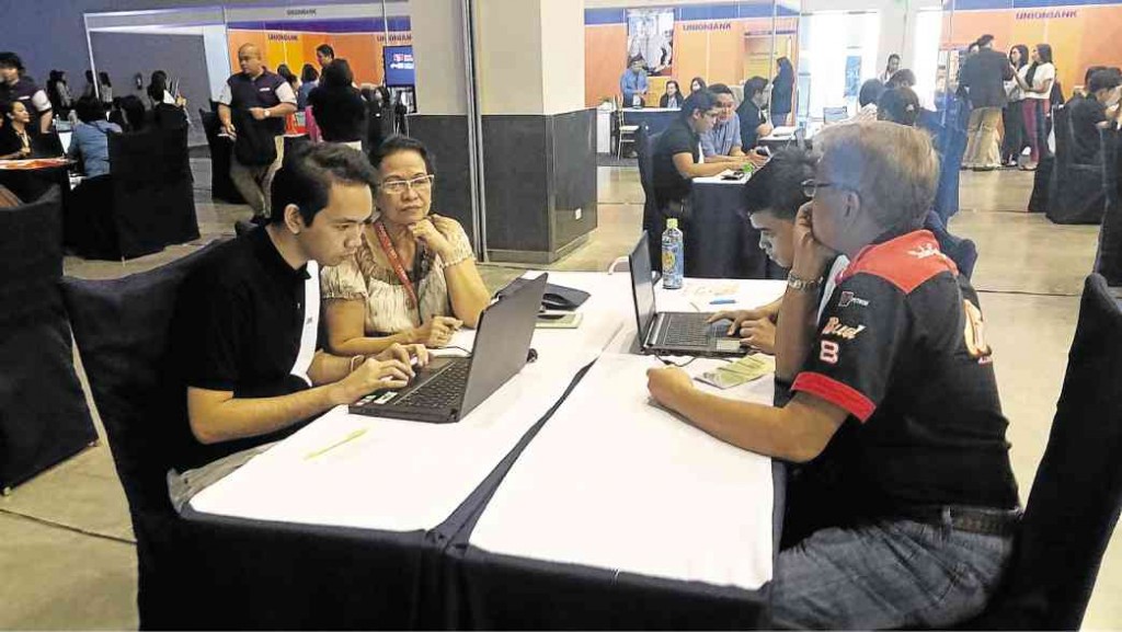 Student volunteers help entrepreneurs in Iloilo put up their company website during the Ureka e-commerce forum at the Iloilo Convention Center.
