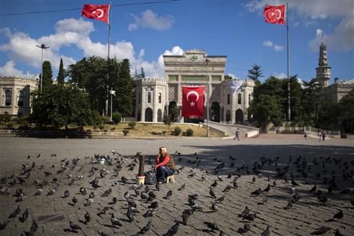 A woman waits for customers to sell food for pigeons outside the Istanbul University Tuesday, July 19, 2016. Turkey's state-run news agency says courts have ordered 85 generals and admirals jailed pending trial over their roles in a botched coup attempt. Dozens of others were still being questioned. AP