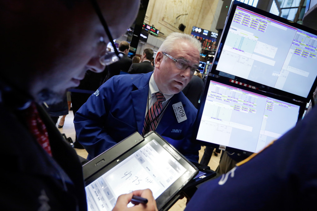 FILE - In this Monday, Sept. 26, 2016, file photo, trader James Dresch, center, works on the floor of the New York Stock Exchange. Energy stocks led most markets higher on Thursday, Sept. 29, after OPEC nations reached a preliminary deal to cut oil production for the first time in eight years. (AP Photo/Richard Drew, File)