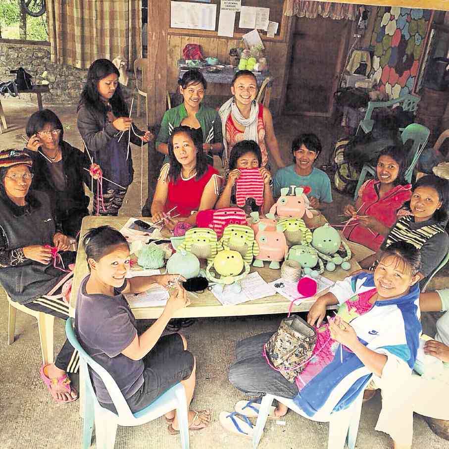 Candy Reyes-Alipio (back row, in red) helps the women of Ifugao use their natural talent for knitting to earn extra income for themselves and their families.