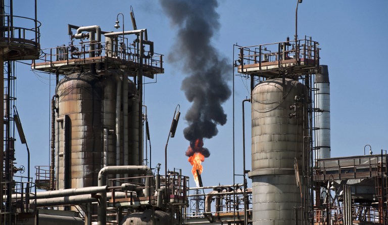 View of the structures to process oil with a flame in the background at Mexican state-owned petroleum company PEMEX refinery in Tula, Hidalgo state, Mexico on March 8, 2011. AFP PHOTO/OMAR TORRES / AFP PHOTO / OMAR TORRES