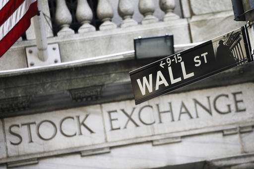 This July 16, 2013, file photo, shows a Wall Street street sign outside the New York Stock Exchange. Asian shares tumbled Monday, Dec. 5, 2016, while Europe opened higher after Italian voters rejected constitutional changes, raising questions over whether the country will stay in the European Union and keep using the euro. AP