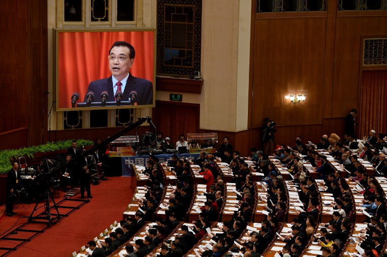 Chinese Premier Li Keqiang is shown on a screen as he delivers his work report during the opening session of the National People's Congress, China's legislature, in Beijing's Great Hall of the People on March 5, 2017.  China's rubber-stamp congress opened on March 5, 2017 in an annual pageant of Communist-controlled democracy. / AFP PHOTO / GREG BAKER