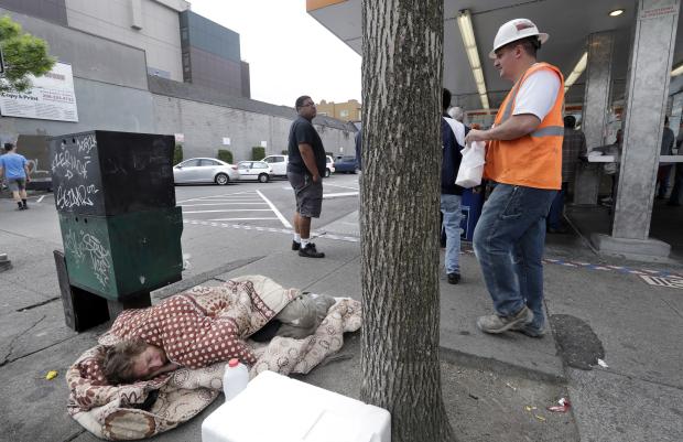 Homeless man sleeping on sidewalk in Seattle