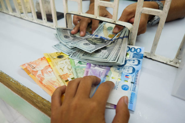 Stock photo at moneychanger showing Philippine peso and US dollar bills. STORY: Pressured peso nears 17-year low vs US dollar