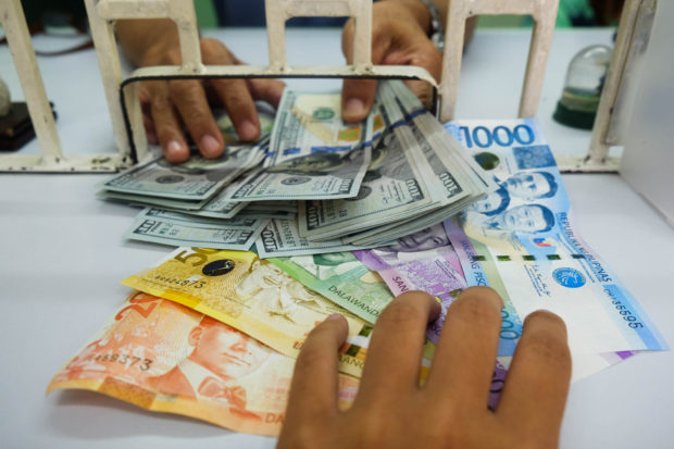 Peso to dollars at money exchange window. STORY: Concern over slowing OFW remittances growth rising