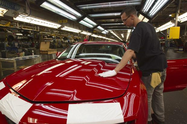 Worker checks a Camaro at GM plant in Canada