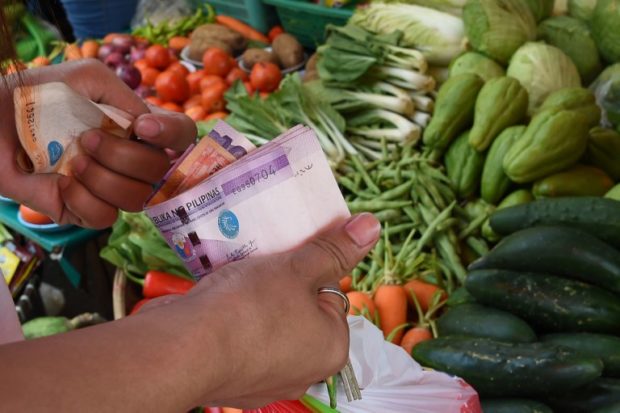 Closeup of customer's hands as she buys vegetables. STORY: May inflation rate heats up to 42-month high of 5.4%