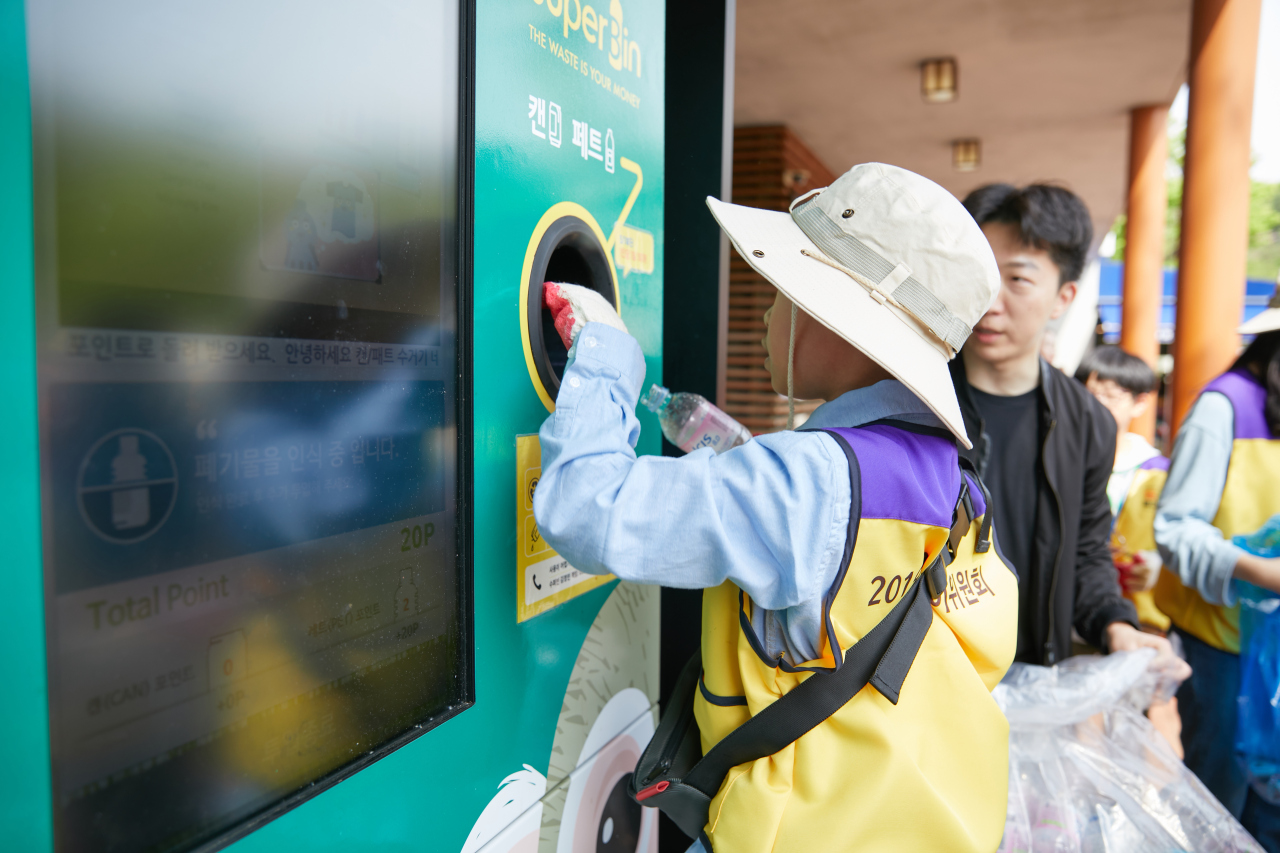 SuperBin customers recycle plastic bottles in Seoul with the reverse vending machine Nephron. (SuperBin)