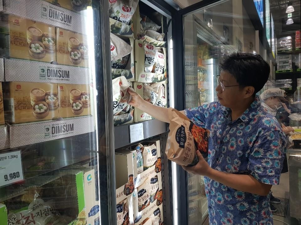 Jo Nam-kyu, a salaried worker, selects ready-made products at an E-Mart Traders outlet in Hanam, just east of Seoul, on Aug. 18, 2019. (Yonhap via The Korea Herald/Asia News Network)