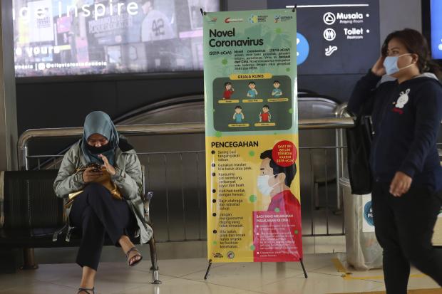 Women in masks in a Jakarta train station