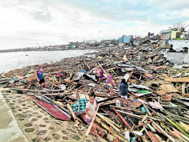 REBUILDING  Residents of Ubay, Bohol, dig through piles of debris to find anything they can use to rebuild their homes destroyed by Typhoon “Odette,” as it battered the Visayas and Mindanao last week.  —LEO UDTOHAN