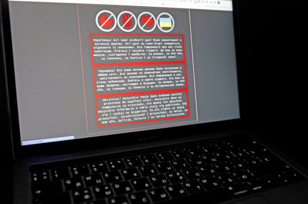 FILE PHOTO: A laptop screen displays a warning message in Ukrainian, Russian and Polish, that appeared on the official website of the Ukrainian Foreign Ministry after a massive cyberattack, in this illustration taken January 14, 2022. REUTERS/Valentyn Ogirenko/Illustration/File Photo
