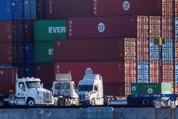 FILE PHOTO: Trucks arrive to pick up containers at the Port of Los Angeles in Los Angeles, California, U.S. November 22, 2021. REUTERS/Mike Blake