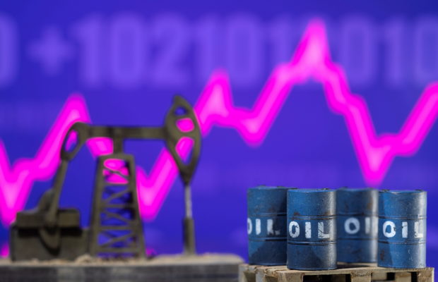 FILE PHOTO - Models of oil barrels and a pump jack are displayed in front of a rising stock graph and "$100" in this illustration taken February 24, 2022. REUTERS/Dado Ruvic/Illustration 