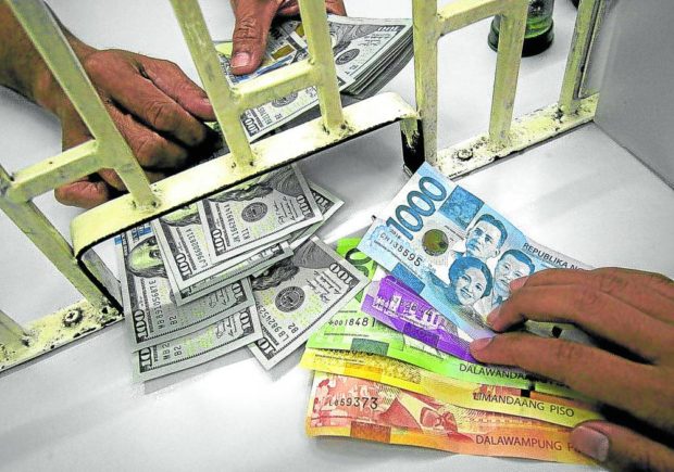 FALTERING PESO A customer transacts with a money changer in Manila. The peso is expected to weaken to 53.50:$1 by June. STORY: Peso to further weaken as trade deficit widens