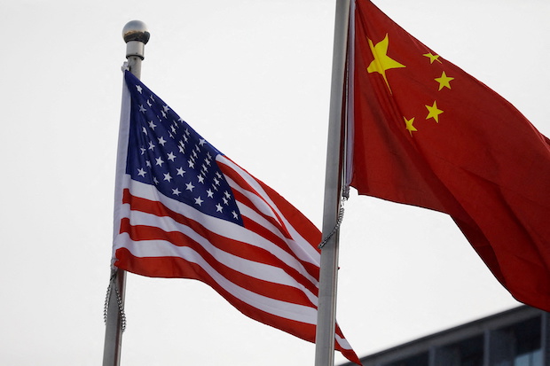 Chinese and US flags flutter outside the building of an American company in Beijing. STORY: US mulls lifting some China tariffs to fight inflation