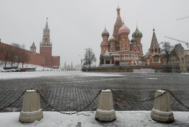 FILE PHOTO: The clock on Spasskaya tower showing the time at noon, is pictured next to Moscow?s Kremlin, and St. Basil?s Cathedral, March 31, 2020. REUTERS/Maxim Shemetov