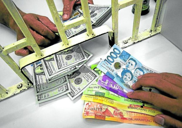A customer exchanges dollars for pesos.  STORY: Peso continues slide, drops past 56:$1