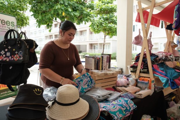 Woman in brown Selling Bags and Hats