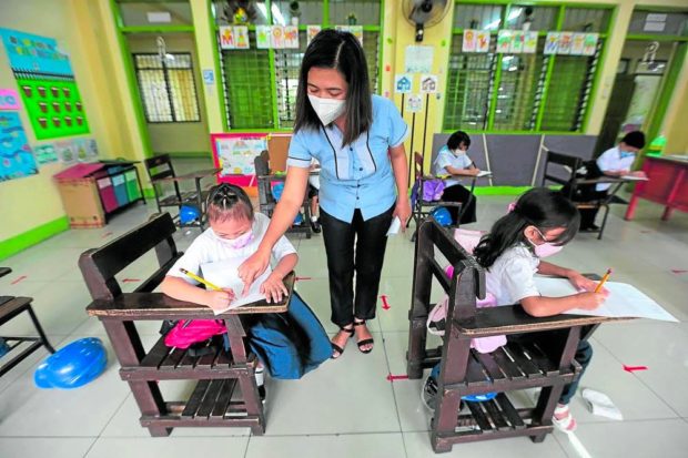 FILE PHOTO: A teacher and her students learn together at the Pedro Cruz Elementary School in San Juan City as it reopened its face-to-face classes on Thursday, February 10, 2022. INQUIRER/GRIG C. MONTEGRANDE