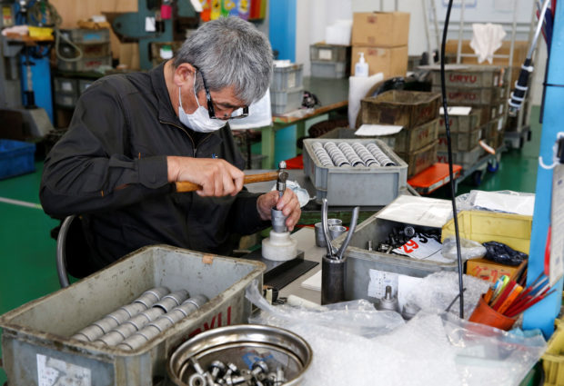 A worker assembles an air drill 