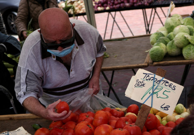 Man buying tomatoes in a market