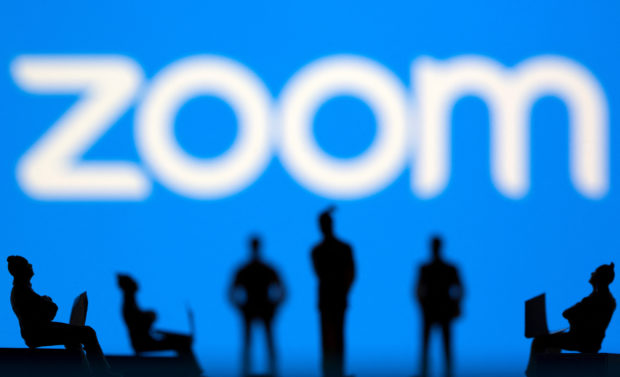Small toy figures in front of Zoom logo
