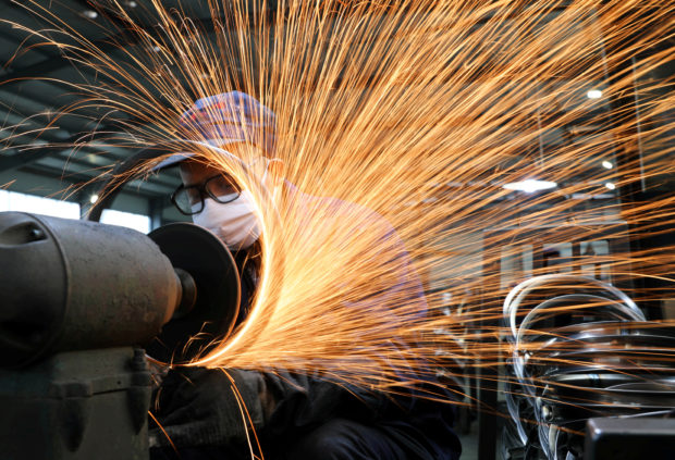 Worker doing welding works in a factory of bicycle steel rim