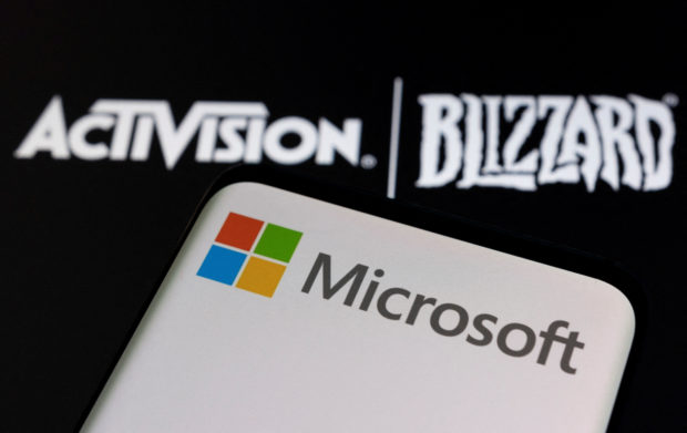 Microsoft logo on a phone with Activision Blizzard logo in background