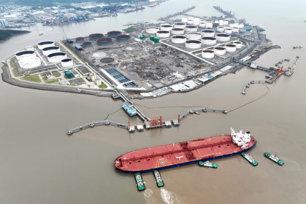 aerial view of tugboats helping a crude oil tanker to berth