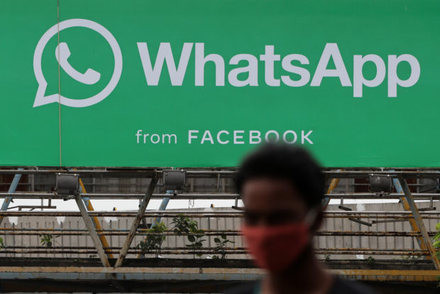 Man in front of WhatsApp sign