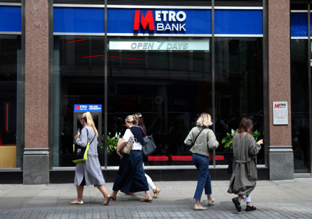 People walk past a Metro Bank branch