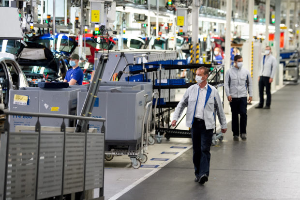 Staff walking by Volkswagen assembly line  in Germany