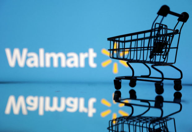 Shopping trolley is seen in front of Walmart logo 