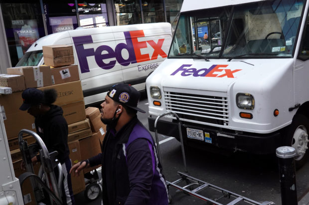 Fedex workers sort packages for delivery