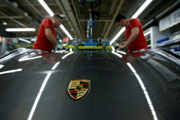 Workers install windshield of a Porsche 
