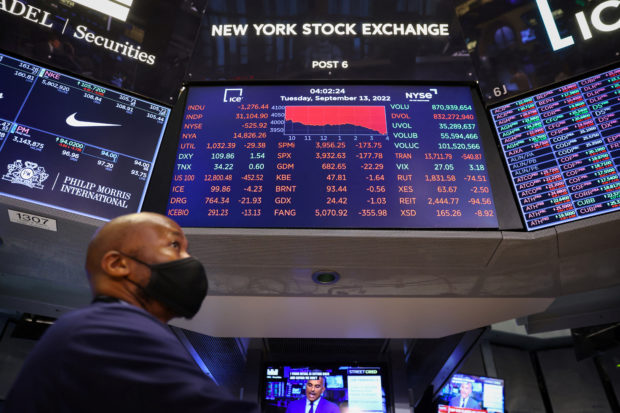 A trader on trading floor with electronic stocks screen in the background