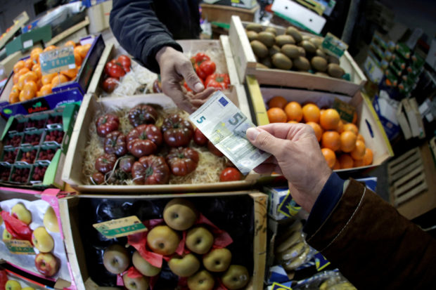 A shopper pay with a euro banknote in a market 