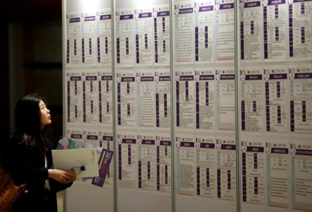Woman looks at recruitment informationn on a board