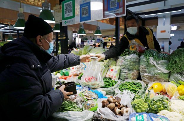 People shop in a market in Beijing