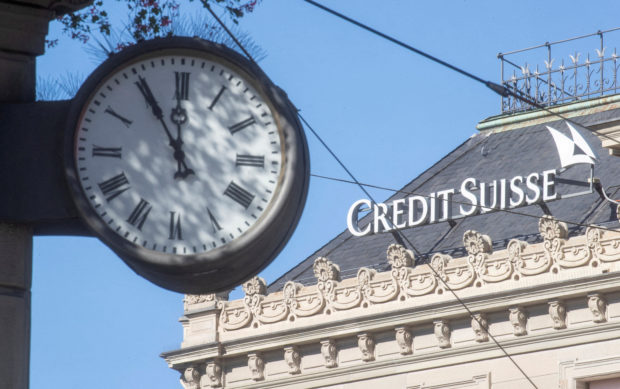 Clock seen with logo of Credit Suisse in background