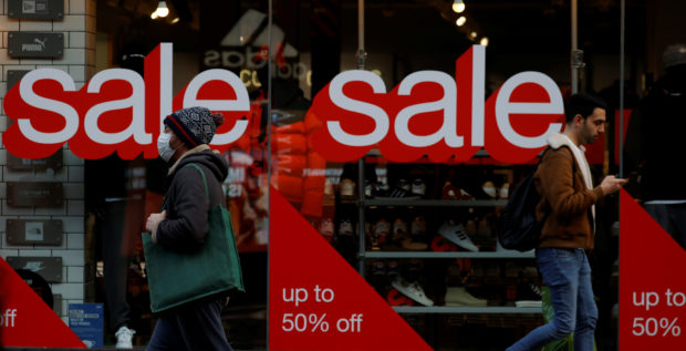 Sale signs on window of shoe shop in Manchester