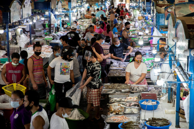 People shop in a public market in Quezon City