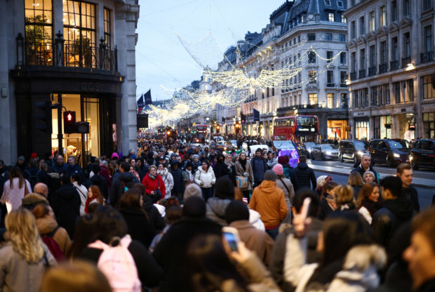 People walk past shops in London
