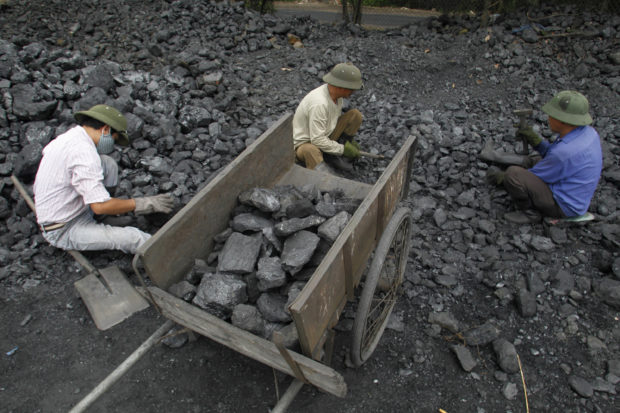 Workers pick out gravel from a ta coal port in Hanoi