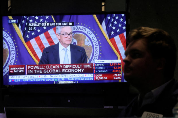A screen displays Fed Chair Powell speaking